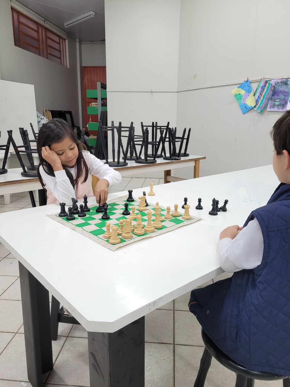 Jogo de xadrez para crianças shool kid jogando xadrez na sala de