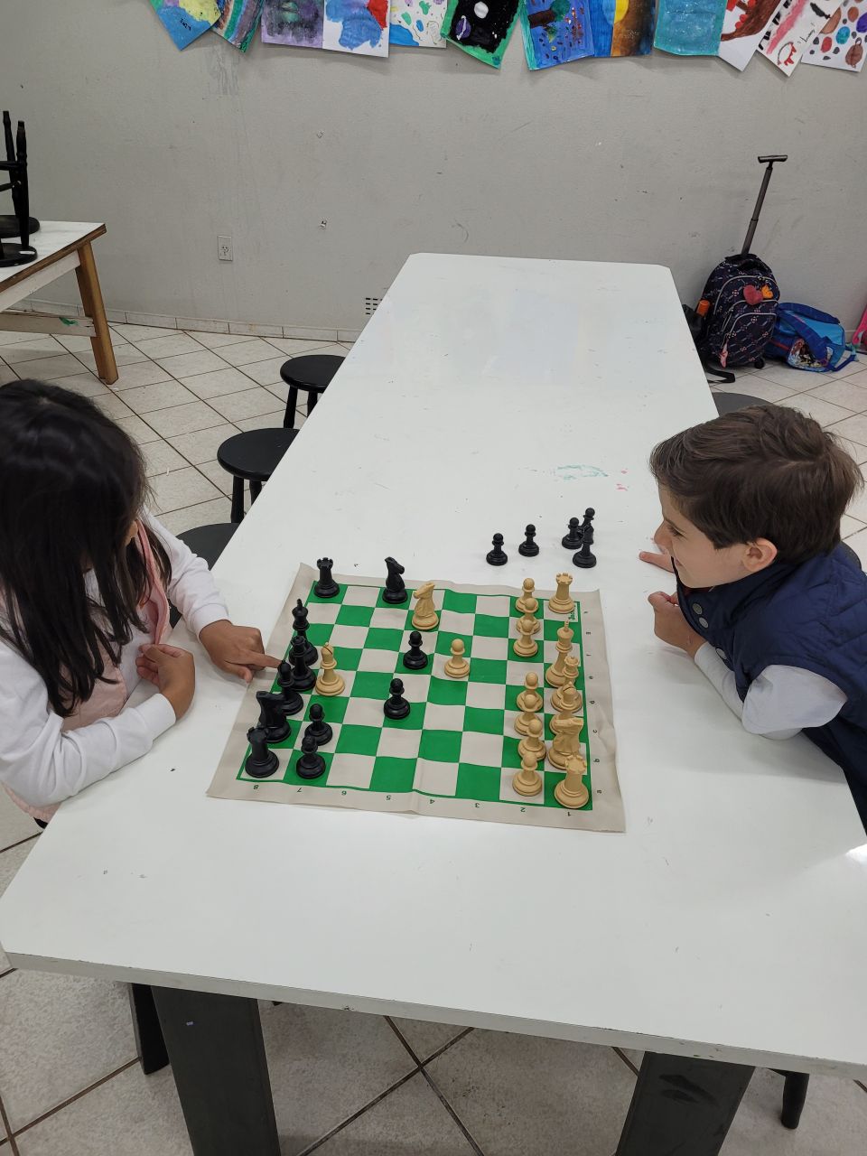 Escola de xadrez xadrez infantil concentrado jogo infantil inteligente  xadrez na biblioteca perto das estantes conceito educacional menino  pensando em xadrez o conceito de aprender e crescer crianças